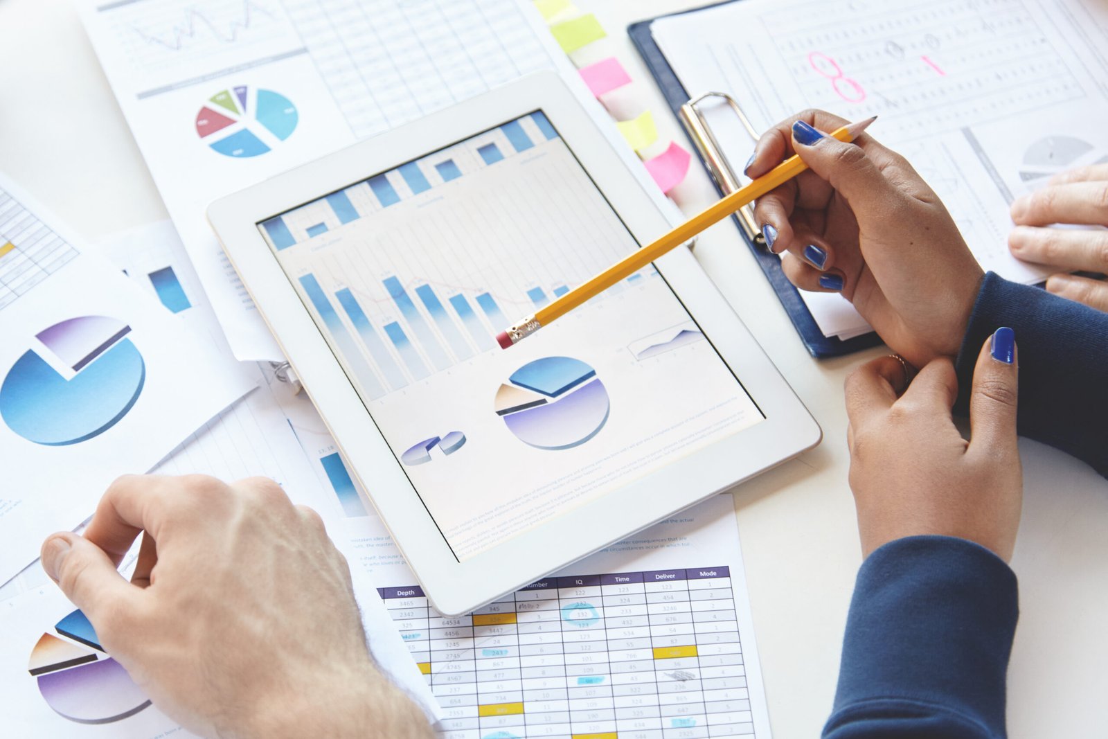 businesspeople sitting table with touch pad notes developing business strategy making changes financial report
